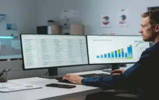 Maintenance planner comparing condition monitoring data and charts on dual monitors