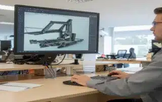 Engineer using CAD software to design a heavy machinery component on desktop